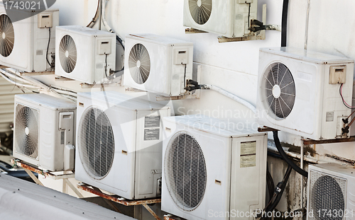 Image of Many older air conditioners on the wall