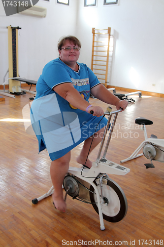 Image of overweight woman exercising on bike