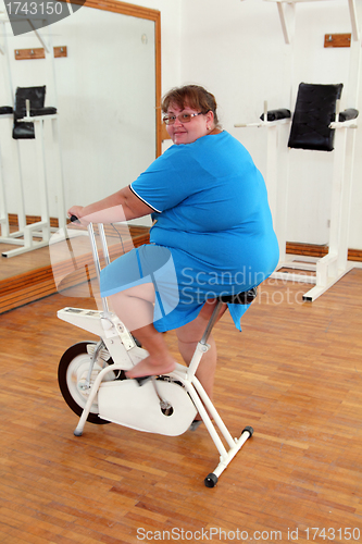 Image of overweight woman exercising on bike