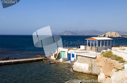 Image of  houses built into rock cliffs on Mediterranean Sea Firopotamos 