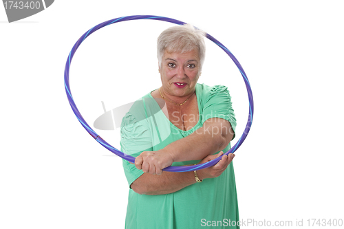 Image of Senior lady doing gymnastic with hula-hoop