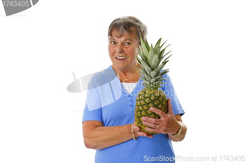 Image of Female senior holding fresh pineapple