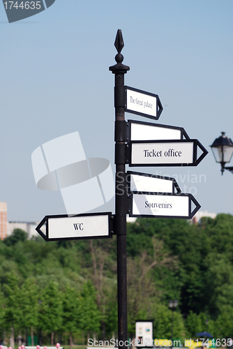 Image of directional  arrow sign in a city park crossroad 