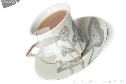 Image of cup of coffee with milk or cream and saucer 
