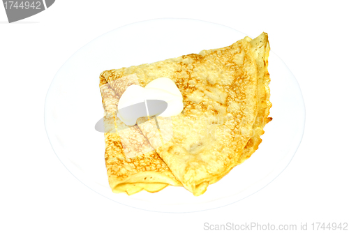 Image of one pancake with a sour cream on a plate