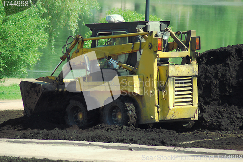 Image of Mini excavator-grab working in city park  at the spring