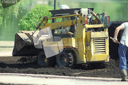 Image of Mini excavator-grab working in city park  at the spring