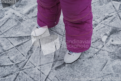 Image of child  foots with skates on ice