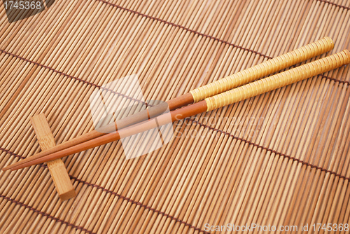 Image of Chopsticks on brown bamboo matting background 