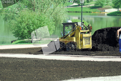 Image of Mini excavator-grab working in city park  at the spring