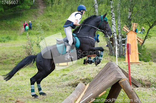 Image of Eventer on horse is overcomes the cross-country fence