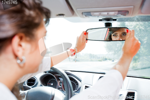 Image of Young woman corrected rear view mirror