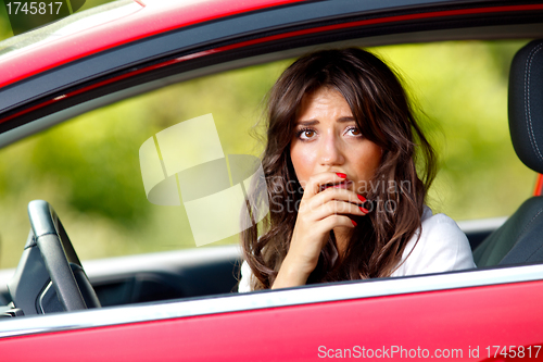 Image of Young pretty scared woman in the car