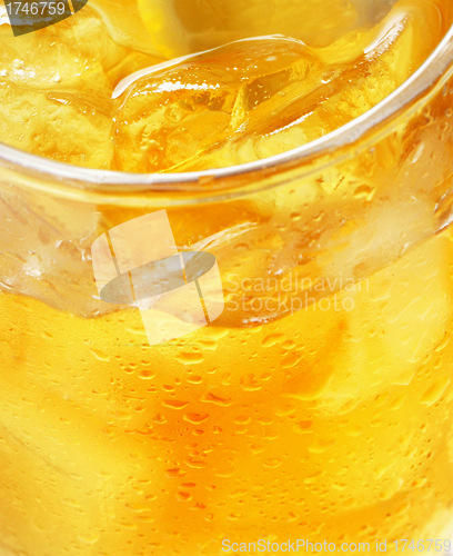 Image of glass of orange juice with ice - macro