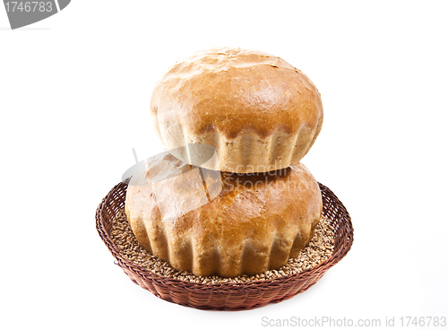 Image of two fresh baked rolls with grain in a basket on white