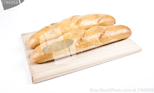 Image of fresh baguette on wooden plate