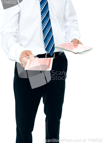 Image of Cropped image of a man holding playing cards