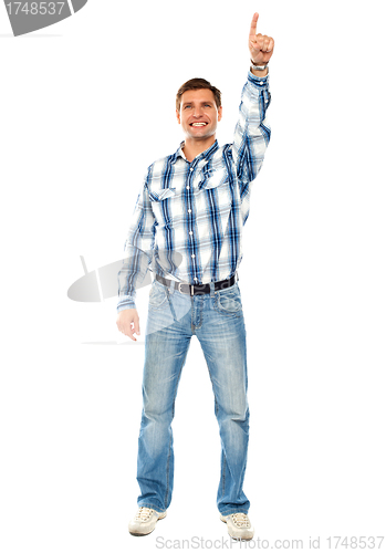 Image of Happy young guy pointing upwards. Full shot