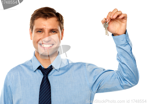 Image of Portrait of smiling businessman holding keys