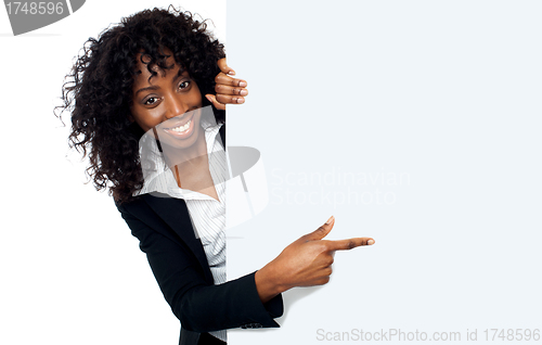 Image of Female representative pointing towards placard