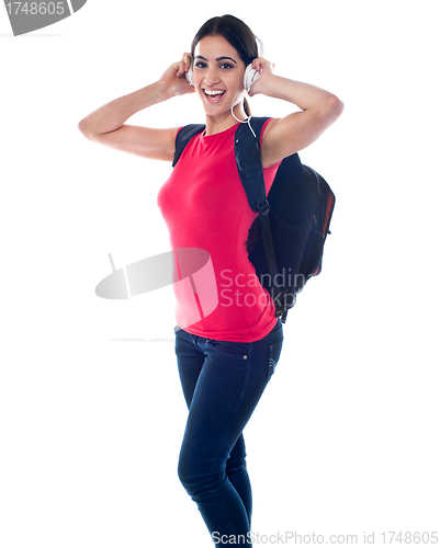 Image of College girl enjoying music through headphones