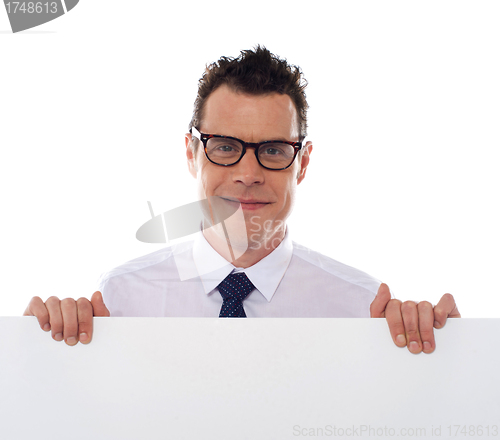 Image of Young man holding blank billboard