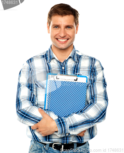 Image of Young man holding clipboard and notepad