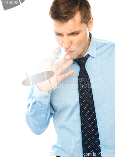 Image of Young corporate male smokes a cigarette