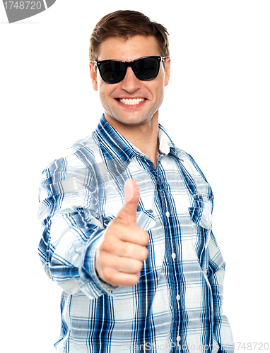 Image of Smart young guy showing thumbs up