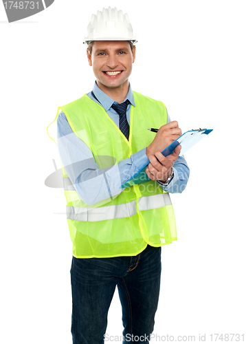 Image of Smiling young architect writing notes