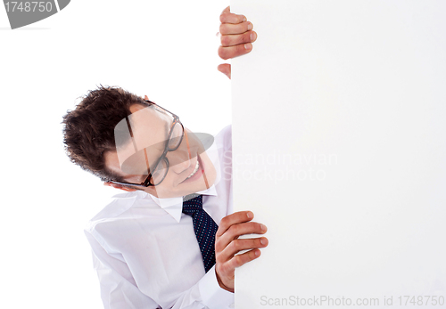 Image of Executive peeping from behind empty signboard