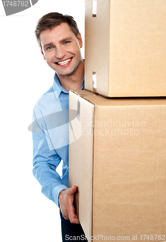 Image of Smiling young man holding cardboard boxes