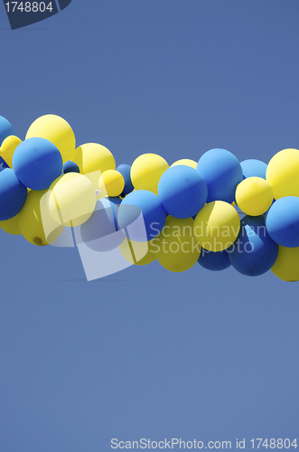 Image of Yellow blue color balloons on background blue sky 