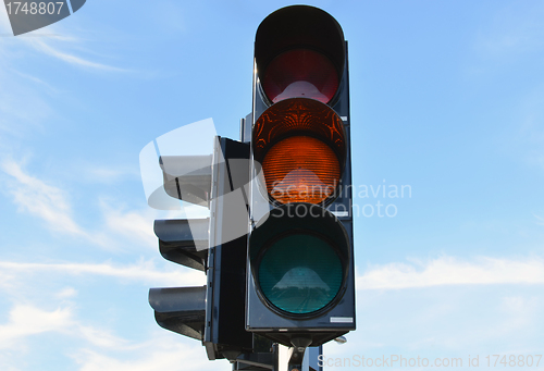 Image of Yellow color traffic light blue sky in background 