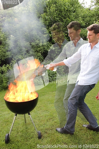 Image of BBQ with fire an young man