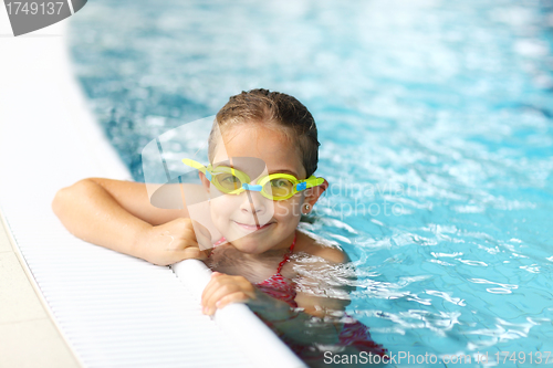 Image of Schoolgirl with goggles in swimming pool