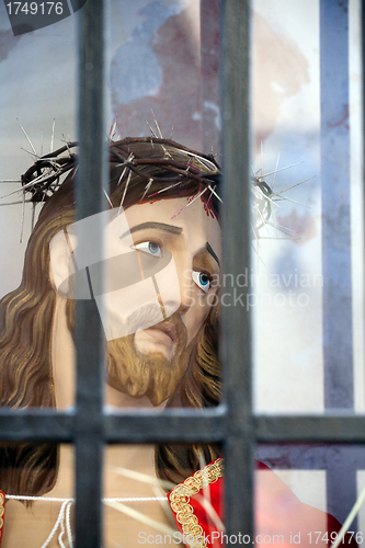 Image of Jesus Christ head statue behind bars