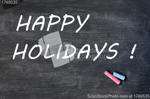Image of Happy holidays written on a smudged blackboard with chalk