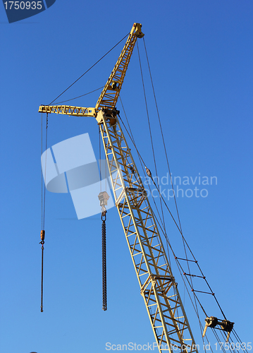 Image of yellow crane and blue sky on building site