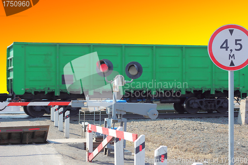 Image of railroad cars at the crossing with a barrier