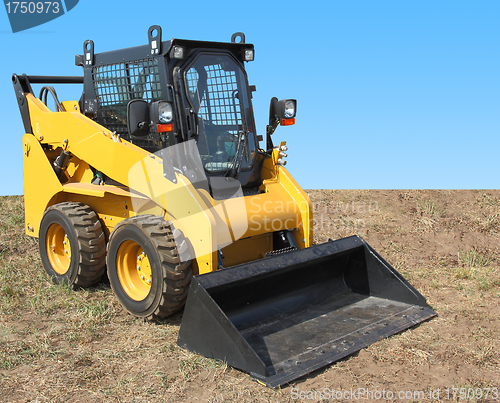 Image of The yellow truck with a scraper to lift cargo.