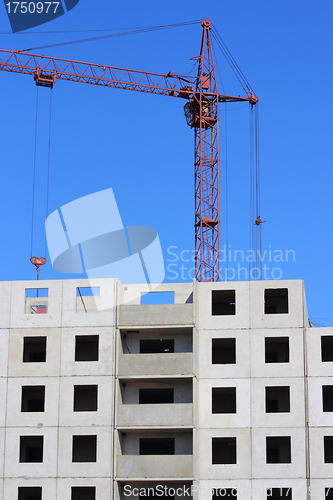 Image of red crane and blue sky on building site