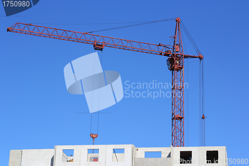 Image of red crane and blue sky on building site