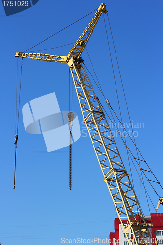 Image of yellow crane and blue sky on building site