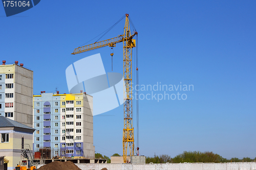 Image of yellow crane and blue sky on building site