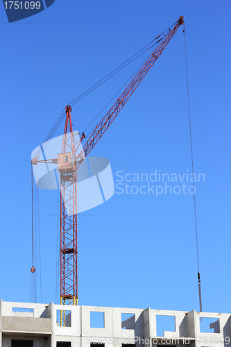 Image of red crane and blue sky on building site