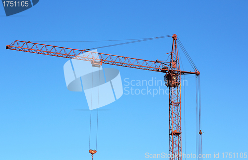 Image of red crane and blue sky on building site