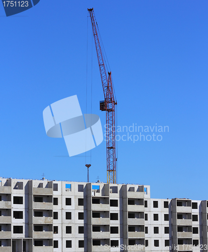 Image of red crane and blue sky on building site