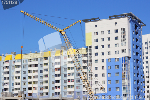 Image of yellow crane and blue sky on building site