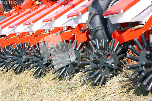 Image of tractor and seeder planting crops on a field